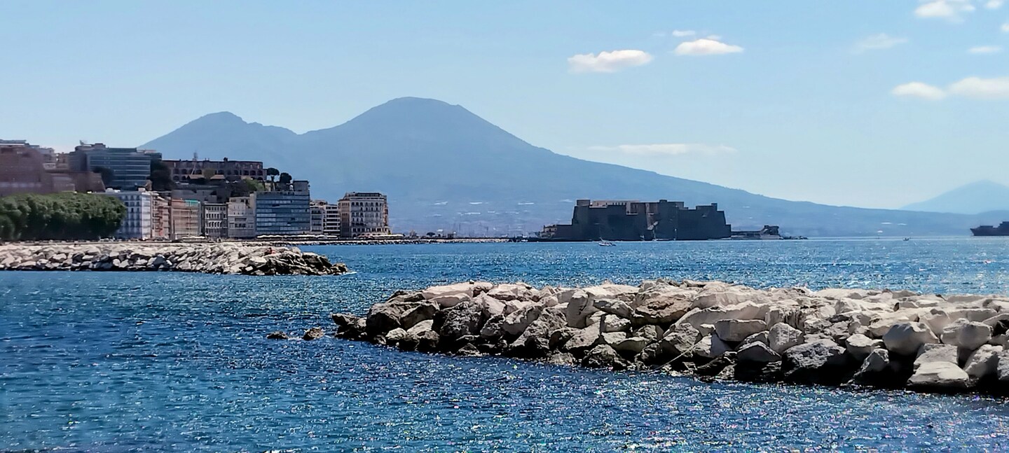 Il mare di Napoli con Castel dell’Ovo e il Vesuvio sullo sfondo, una meta da scoprire durante il soggiorno